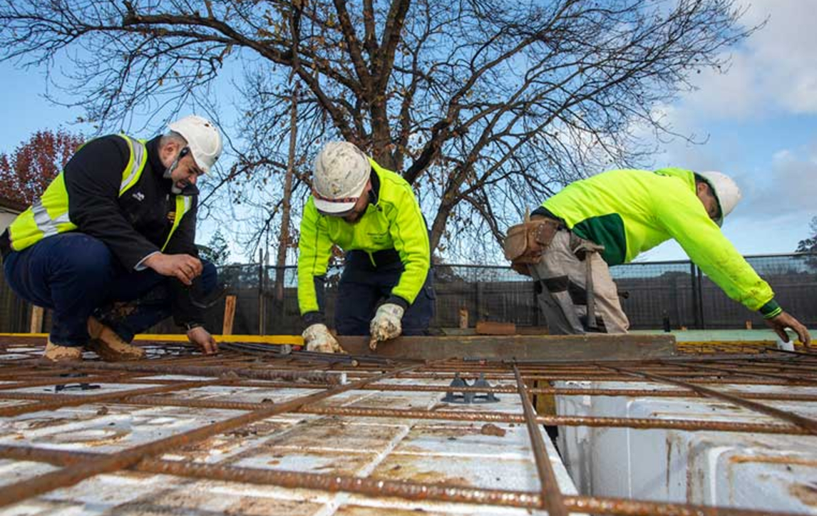 Construction workers working on base slab of house