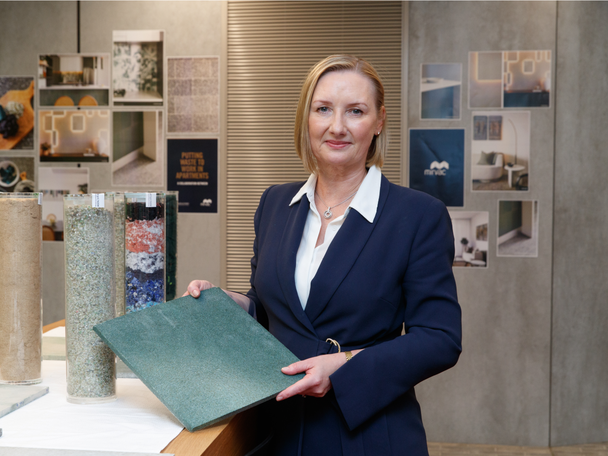 Susan Lloyd-Hurwitz holding tile made out of waste