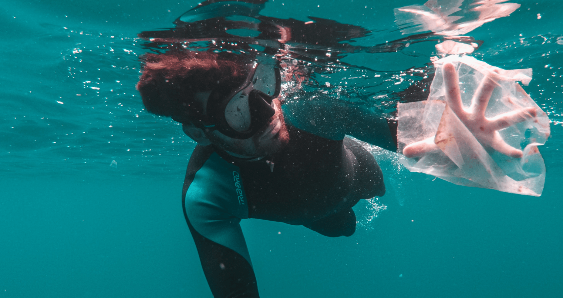 snorkeler swiming into plastic