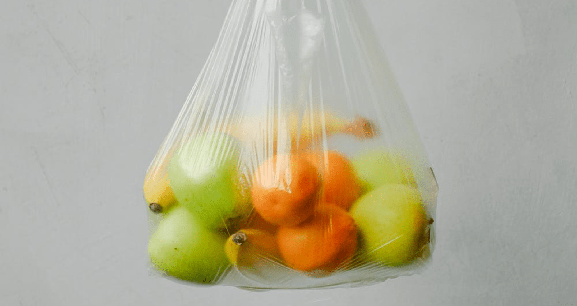 plastic bag filled with apples, oranges and bananas