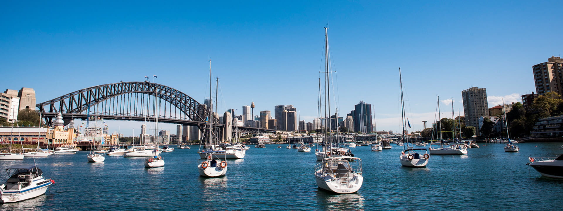 small boats in front of the Harbour Bridge in Sydney